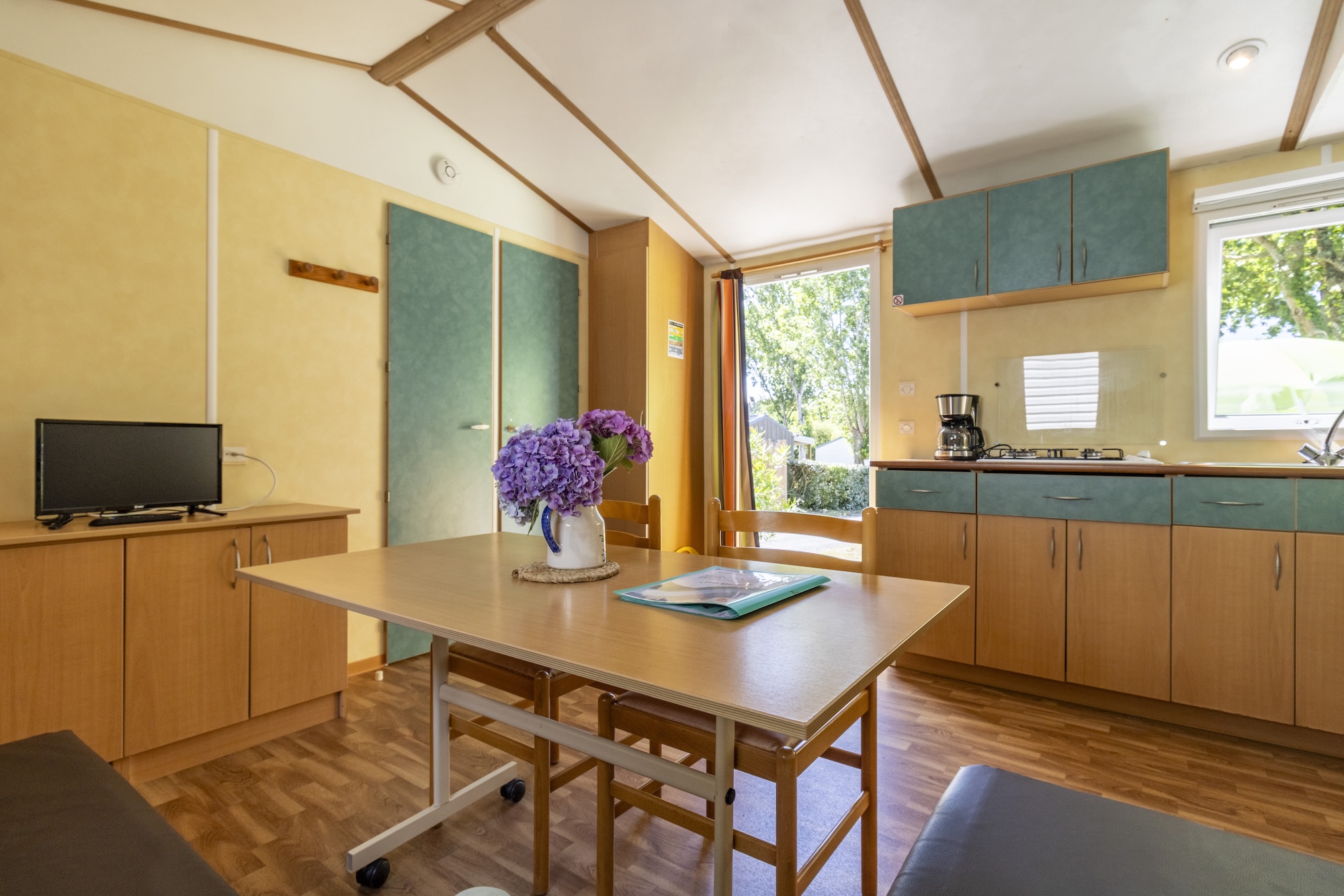 location-mobil-home-basic-2chambres-sejour-television Mobil home basic 2 chambres 4 personnes : Coin repas